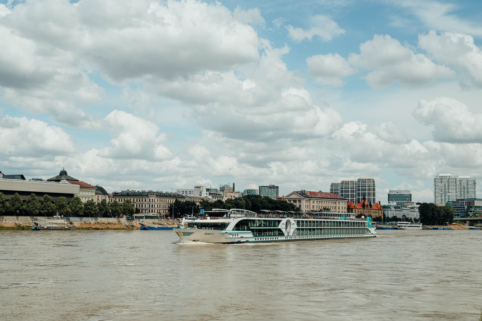 River ship sailing past a city